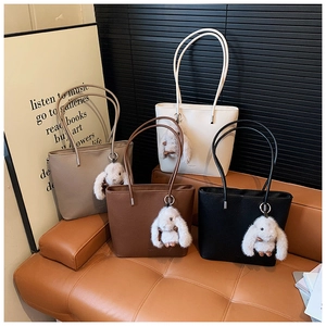 Litchi pattern faux leather tote bags in four colors with cute bunny charms on a sofa