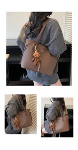Close-up of brown oversized tote bag featuring a cute plush bear charm and sleek straps