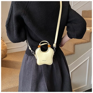 Chic pale yellow bucket bag with unique wave shape and decorative wooden beads detail