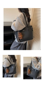 Close-up of black tote bag with fine leather texture and cute brown plush bear charm