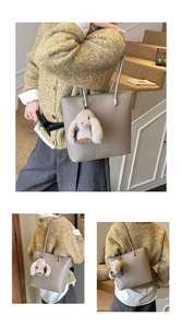 Detail of taupe litchi grain tote bag with elegant logo and cute rabbit plush charm