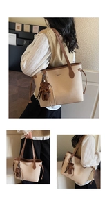 Close-up of beige tote bag with leather trim and brown plush bear charm