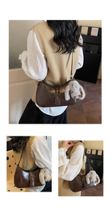 Detail of dark brown glossy underarm bag with metal buckle and plush bunny charm