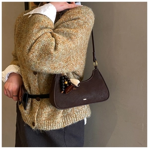 Gros plan d'un sac hobo marron rétro avec breloques vintage et style en maille chic