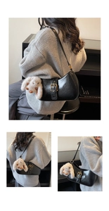 Detail of a vintage black saddle bag with a metallic buckle and a cute plush bunny charm