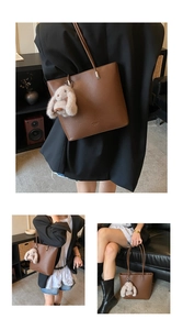 Detail view of brown pebbled leather bucket bag with a cute plush rabbit charm