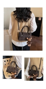 Detailed view of dark brown crossbody bag with contrast stitching and bear charm