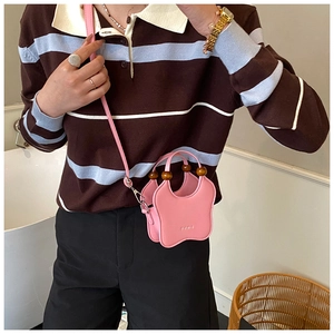 Detail of pink butterfly-shaped mini crossbody bag with a round wooden bead handle