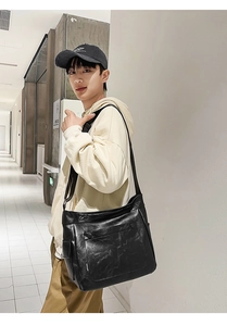 Detail view of large black faux leather tote bag with side pocket and magnetic flap