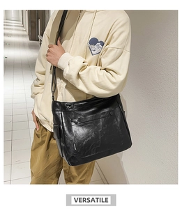 Detail view of black PU leather crossbody bag with metal snap button and brand label