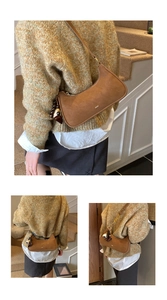 Détail du sac demi-lune marron mat avec pompon en perles et petite plaque métallique