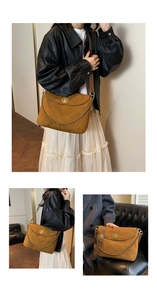 Detail of brown quilted suede messenger bag with gold chain and twist lock closure