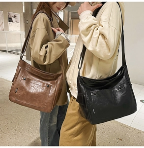 Close-up of Large PU leather messenger bag with side pockets and adjustable shoulder strap