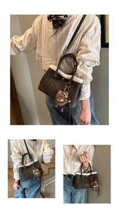 Detail of vintage grey suede tote bag with white faux fur trim and cute bear charm