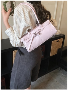 Détail du sac à épaule en cuir rose avec nœud papillon et boucle de ceinture élégante