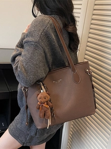Retro dark brown large tote bag with teddy bear charm shown on model in soft light
