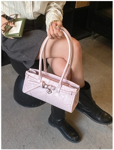 Détail d'un sac à main rose brillant montrant la boucle en métal et le design chic