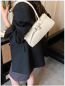 Sac à bandoulière baguette beige minimaliste porté par un mannequin, vue de profil et texture