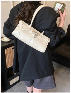 Vue détaillée du sac baguette minimaliste blanc cassé avec boucles argentées et sangle