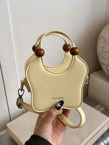 Star-shaped pale yellow handbag with wooden beads and a detachable shoulder strap