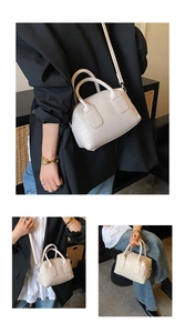 Detailed macro view of the cream white lychee texture leather on a stylish Boston bag