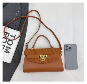 Brown crossbody bag with wave texture and gold lock shown beside a smartphone for size