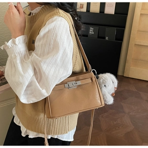 Detail of retro camel leather Kelly bag with silver lock and plush bunny charm