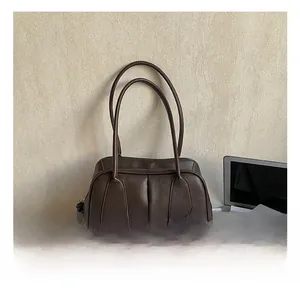 Detail of dark brown leather tote bag with unique knot zipper and sleek modern finish