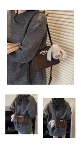 Detail of dark brown retro shoulder bag with silver twist lock and plush rabbit charm
