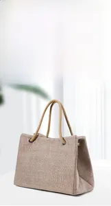 Detail of canvas tote bag with thick woven handles and dark metal ring connectors