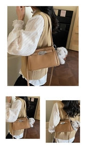 Detail view of a vintage brown leather shoulder bag with a silver lock and plush charm