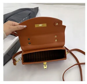 Detail of caramel leather shoulder bag showing the internal compartment and striped lining
