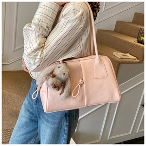 Close-up of pink leather shoulder bag with side knot detail and bunny pendant