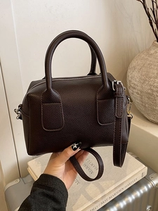 Brown lychee leather bowling bag with dual handles and adjustable strap for women