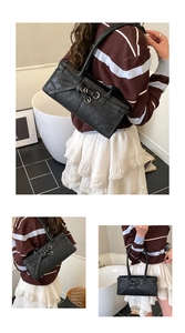 Détail du sac bandoulière rectangulaire noir avec sangles croisées et boucle en métal