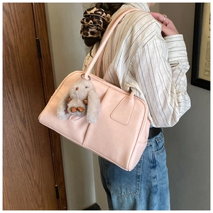 Pink Boston shoulder bag with cute rabbit pendant shown from side on model