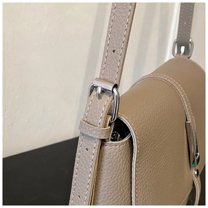 Detail of adjustable silver buckle on khaki lychee grain leather shoulder strap