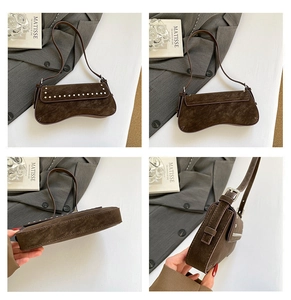 Detail view of brown suede underarm bag featuring silver rivets and curved base design