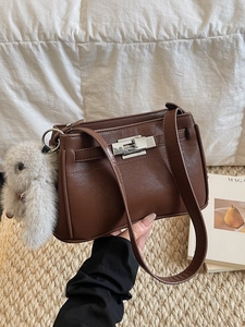 Brown vintage leather Kelly bag with silver metal lock and gray plush rabbit charm