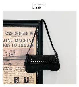 Detail of black suede shoulder bag with silver studs on retro newspaper background