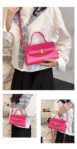 Detailed view of hot pink crossbody bag with wave texture and gold chain link details