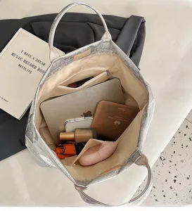 Spacious interior of a metallic silver tote bag with multiple pockets for daily essentials
