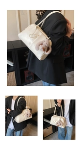 Detail of minimalist cream leather bowling bag featuring a cute plush bunny charm on the side