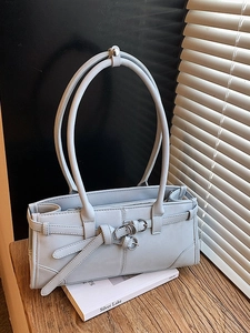 Sac à main minimaliste en cuir bleu clair avec boucle élégante sur une surface en bois