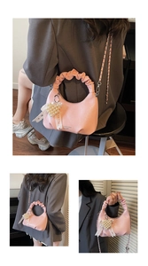 Pink pleated handbag with pearl fringe detail and elegant lace ribbon charm accessory