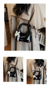 Detail of black pleated handbag with pearl cluster charm and lace bow chain strap