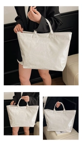 Dettaglio della texture a pelle di serpente e rilievo TOTE BAG sulla borsa beige lucida