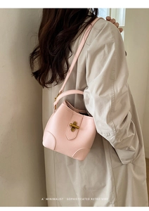 Close-up of pink lychee textured leather bucket bag with golden retro knob closure