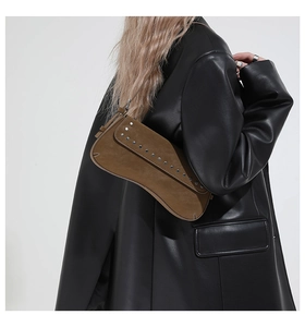 Detail of vintage brown leather handbag with silver rivets worn over the shoulder