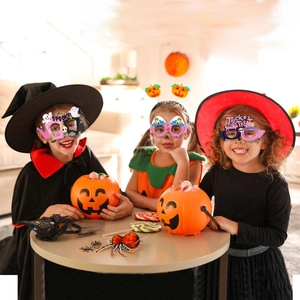 Bambini che indossano occhiali di carta di Halloween con zucche e fantasmi a una festa